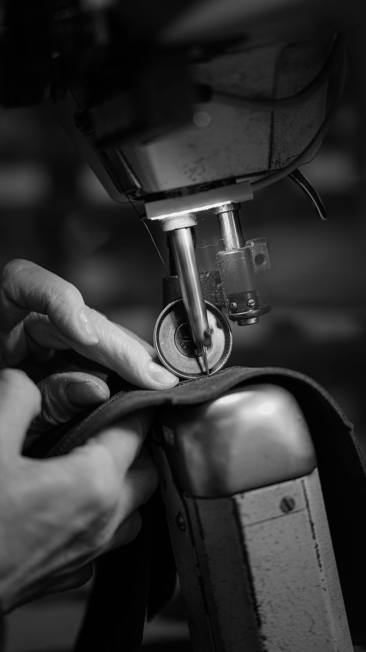 Hand-stitching a leather piece in the atelier